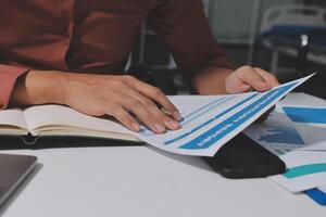 Businessman's hands on paper with graphs and charts photo