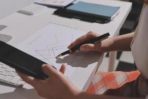 A person is using a pen and a phone to write on paper photo