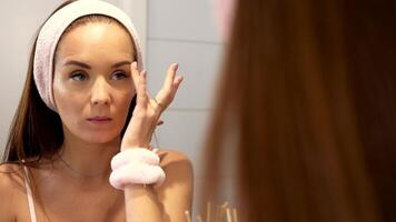 Tapping under-eye serum with fingertip during morning beauty routine video