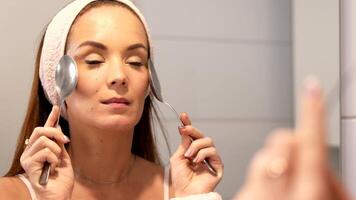 Cooling facial massage with spoons on smile lines for anti-aging skincare video