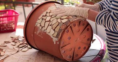 Step by step process showing how to craft a stunning mosaic flower pot using broken tiles and adhesive. Perfect for anyone looking to add personality to their gardening space. video