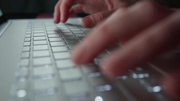 Close-up of hands typing on laptop keyboard. Fingers pressing illuminated laptop keys video