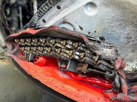 Close-up of a severely burned LED tail light module from a car, showing melted plastic housing, exposed electrical components, and heat-damaged internal structure photo