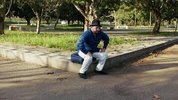 Tourist Taking A Break Sitting On His Suitcase video