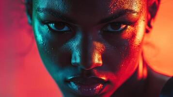 Intense portrait of young african female athlete with focused expression under vibrant red and orange lighting, highlighting determination and strength. Ring boxing competitions photo