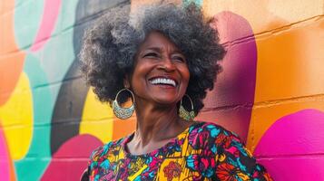 Vibrant elderly african female smiling in colorful patterned dress against a bright urban graffiti wall of dynamic colors representing joy and creativity photo