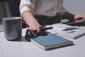 A person is sitting at a desk with a notebook and a cup photo