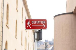red road sign with a direction arrow and the inscription DEVIATION in French. Concepts of change and modification photo