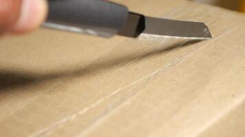 Opening a cardboard box with a utility knife in a workspace area video