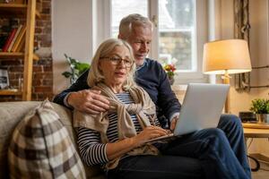 Couple enjoys a cozy afternoon together, sharing laughter and stories while using a laptop in their comfortable living room photo