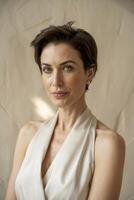 Elegant woman in a sophisticated outfit poses gracefully against a soft backdrop in an artistic portrait capturing timeless beauty photo