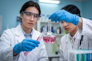 Two scientists in a laboratory working diligently with colorful liquids in glass beakers during a research experiment photo