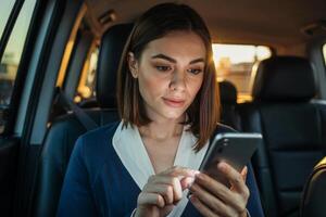 Young businesswoman engaged in focused work inside a modern car during a productive evening commute photo