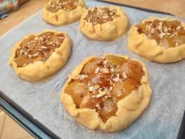 unbaked rustic apple galette with mascarpone and almonds arranged on baking paper before going into the oven photo