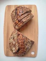 freshly cut artisanal sourdough bread showing crumb and texture on a rustic wooden surface on white table top down view photo