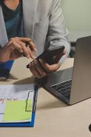 A person using a cell phone and laptop computer photo