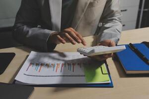A man in a suit is using a calculator to look at a chart photo
