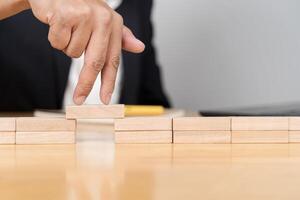 Businessman solving problems. Businessman hand walking across risk between wood blocks. photo