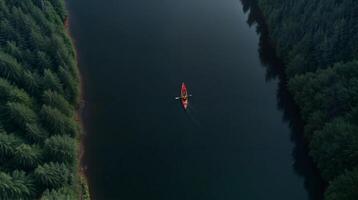 Kayaker paddles quietly in calm waters surrounded by dense forest at twilight in tranquil river setting photo