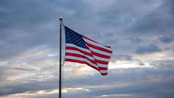 An american flag is flying in front of a cloudy sky video