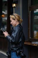 female photographer with cameras and smartphone in hand wait patiently for their next photo shoot. focused expressions hint at their creative mindset.