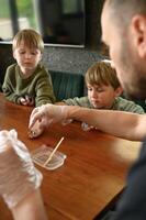 Dad and kids in cozy home setting doing hands on chemistry. Childrens joyful expressions light up the room. photo