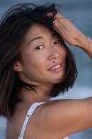 Wet strands frame her sharp features, lips parted slightly, eyes thoughtful. photo
