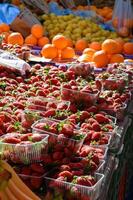 Fresh strawberries at a market, bright red and juicy, arranged in wooden baskets under the sunlight. photo