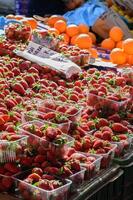 A close-up of ripe strawberries with green leaves, highlighting their freshness and vibrant color. photo