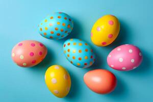 A playful arrangement of Easter eggs with polka dot patterns rests on a blue background. The eggs are painted in cheerful colors-adorned with bright creating a whimsical and festive scene. photo