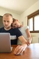 Father and daughter in a cozy home office. Little girl looks up, hoping to play. photo