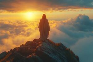 Jesus standing on top of a mountain at sunset photo