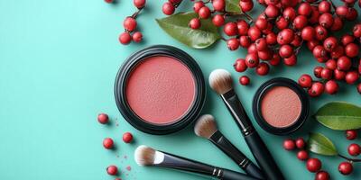 Blush cosmetics and brushes arranged artistically with red berries and leaves on a turquoise background photo