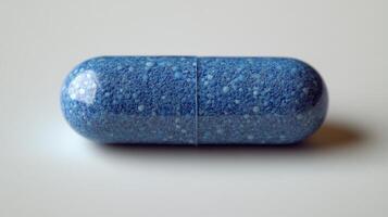 Colorful blue capsule on a plain surface with a textured pattern showcasing imaginative design and vibrant hues photo