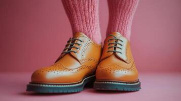 Stylish brown leather shoes paired with pink socks on a vibrant pink background in a fashion-forward setting photo