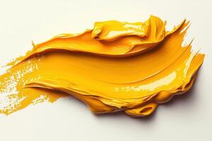 A yellow paint is being poured onto a white surface photo