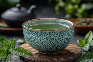Green tea in a cup on a wooden board with mint leaves photo