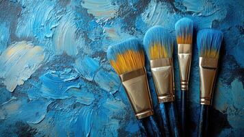 Colorful paintbrushes arranged on a textured blue canvas showcasing artistic tools and vibrant creativity photo