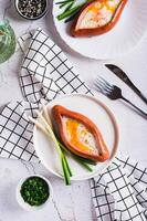 Sausage filled with fried egg and garlic on a plate on a table top and vertical view photo