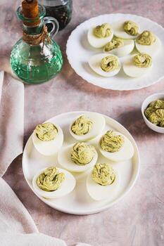 Avocado deviled eggs for appetizer on plate on table vertical view photo