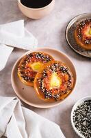 Egg with tomato and sesame seeds baked in bagels on a plate on the table vertical view photo