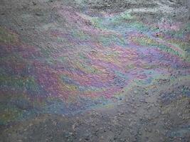 A multi-colored oil stain or gasoline stain caused by a leak from under the car. The concept of environmental pollution. photo