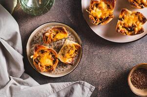 Mini tartlets with caramelized onions and cheese on a plate on a table top view photo