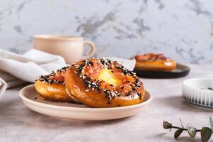 Baked bagels with tomato and quail egg on a plate on the table photo