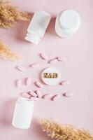 NAD molecule in pills for anti-aging and biohacking on pink top and vertical view photo