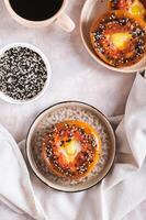 Egg with tomato and sesame seeds baked in bagels on a plate top and vertical view photo