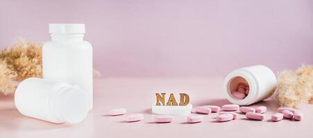 Nicotinamide adenine dinucleotide anti-aging pills and bottles on the table web banner photo