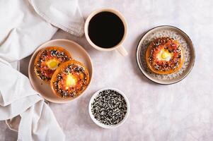 Baked bagels with tomato and quail egg on a plate on the table top view photo
