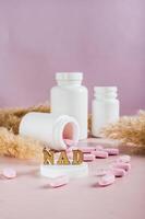Nicotinamide adenine dinucleotide anti-aging pills and bottles on the table vertical view photo