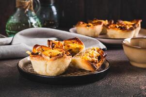 Mini tartlets with caramelized onions and cheese on a plate on a table photo